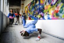 Exposition Beyond the streets Paris - Solo of the Paris City Breakers and dancers in front of a mural by FUTURA 2000. Paris. 1982/84