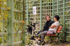 Deux personnes discutent sur un banc dans le jardin Anne Frank